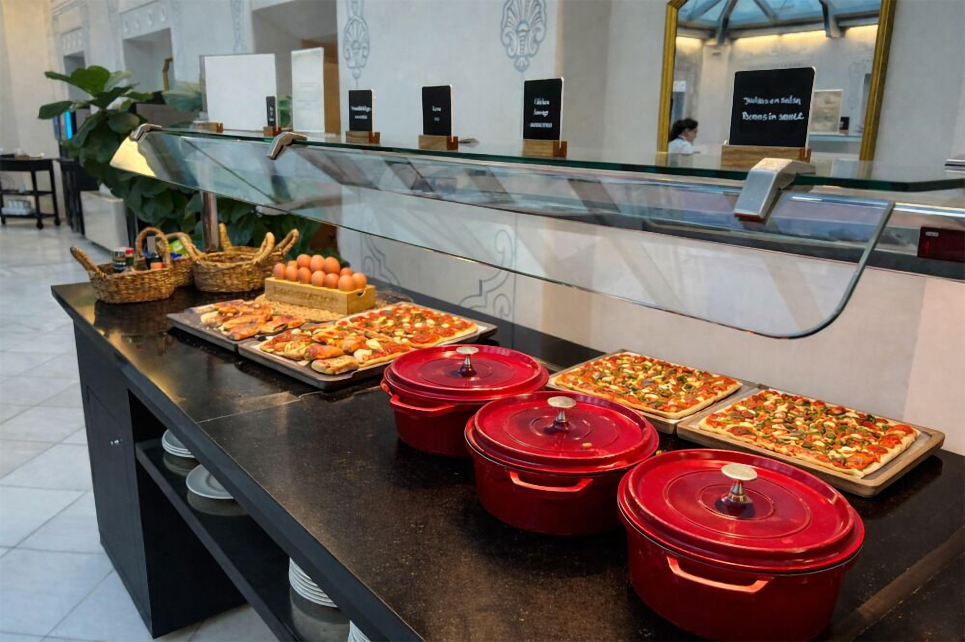 Un buffet con diversi cibi e pentole rosse su un bancone.