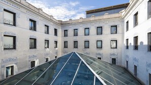 Un edificio moderno con un atrio de cristal y detalles arquitectónicos clásicos.