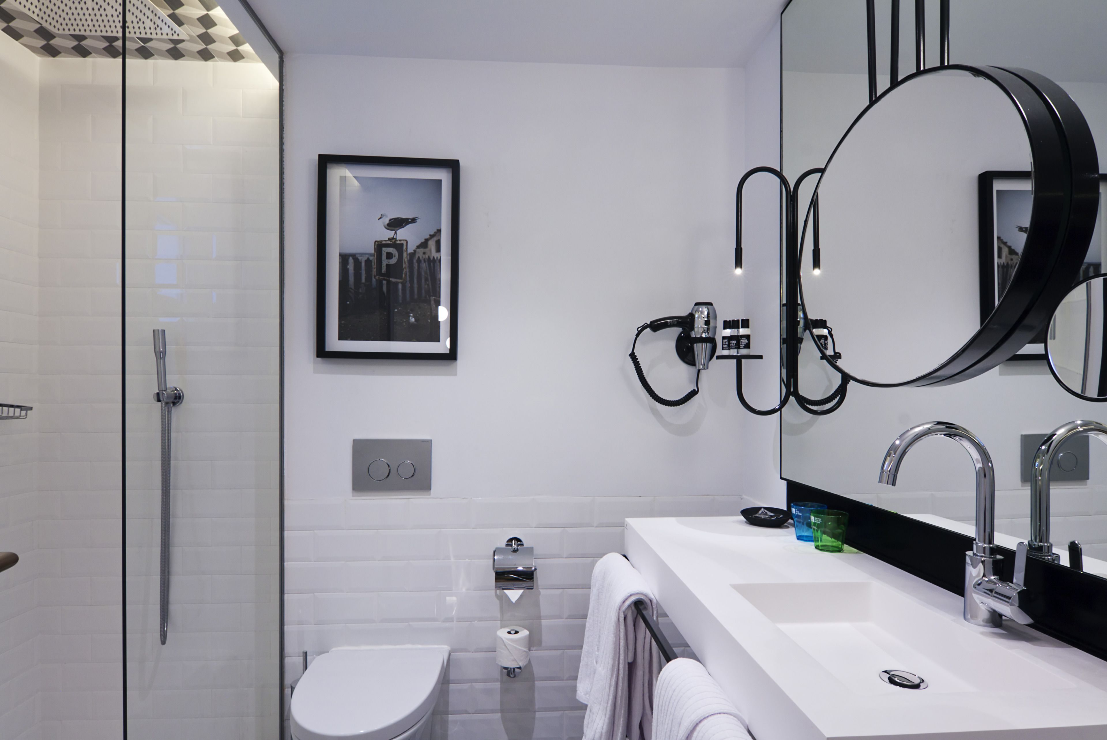 Un baño moderno con ducha, inodoro, lavabo y espejos grandes.