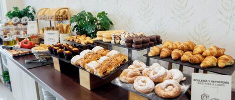 Una vitrina de panadería con diversos pasteles y panes.
