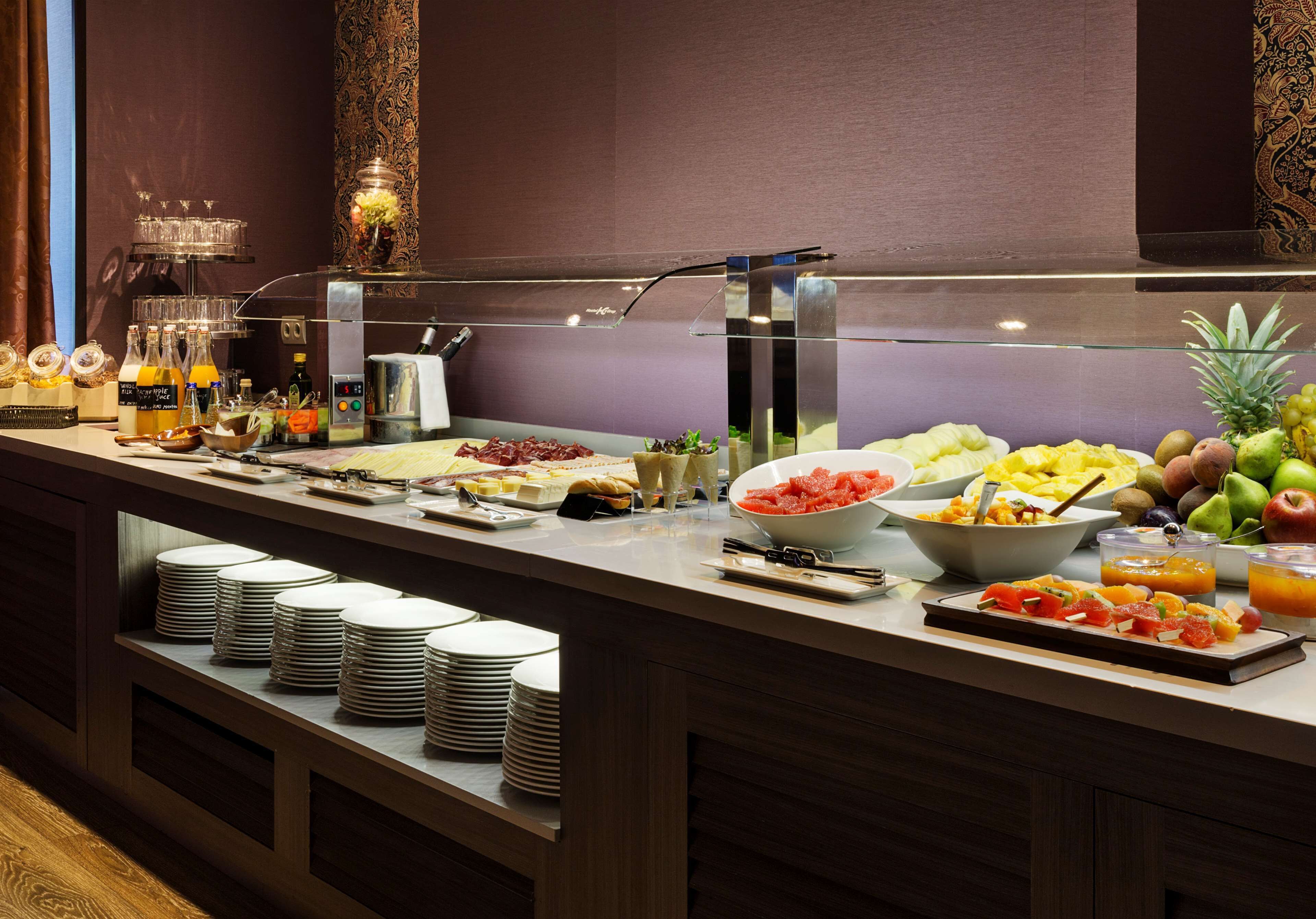 Un buffet proposant une variété de plats et de boissons, notamment des fruits, des légumes et un coin café.