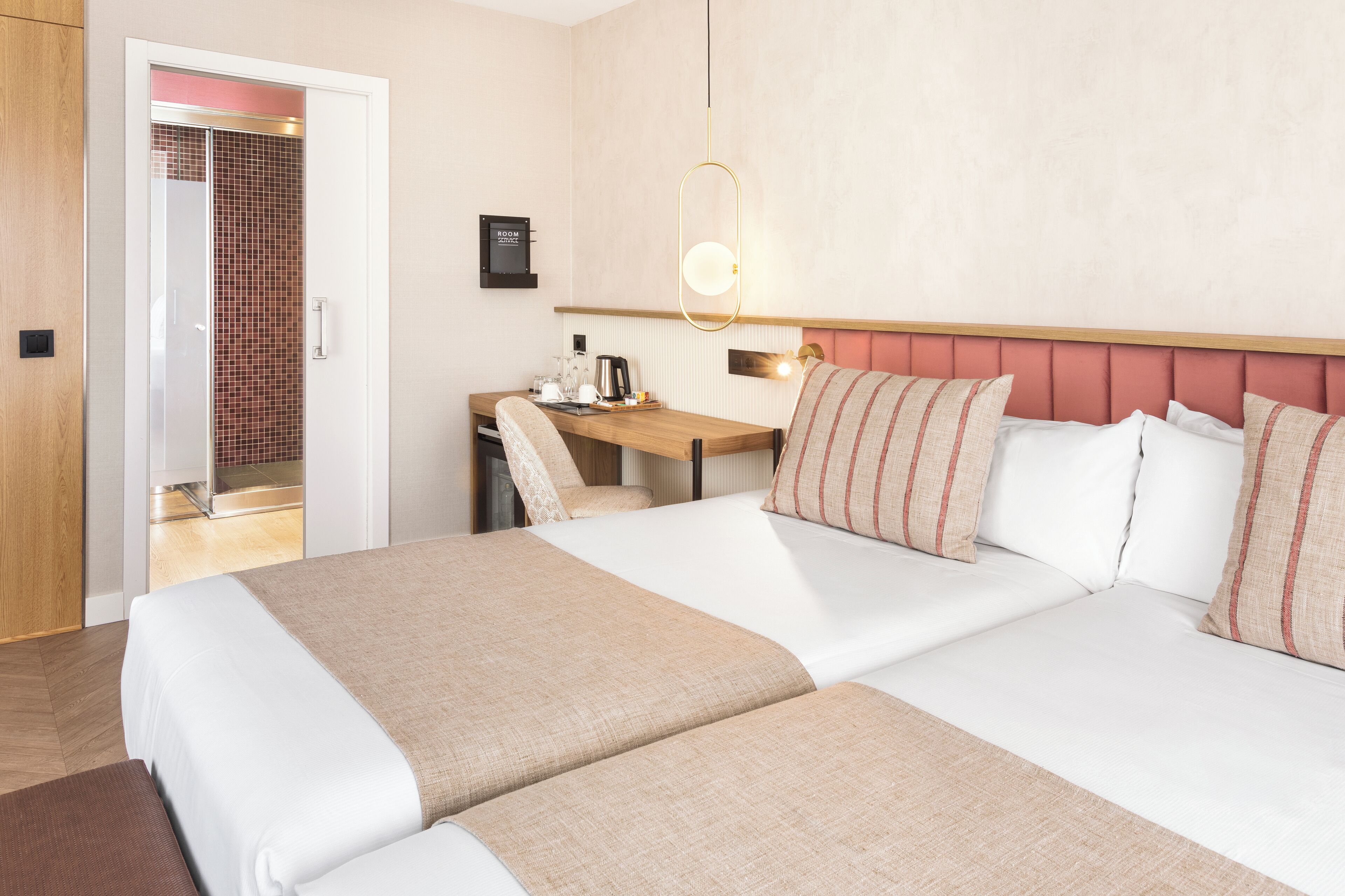 Una habitación de hotel con cama, mesita de noche y escritorio con silla.