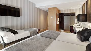 Une chambre d’hôtel avec deux lits, une télévision, un bureau avec une chaise et un espace douche.