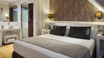 A modern hotel room with a large bed, a bathroom with a sink and mirror, and a patterned wall.