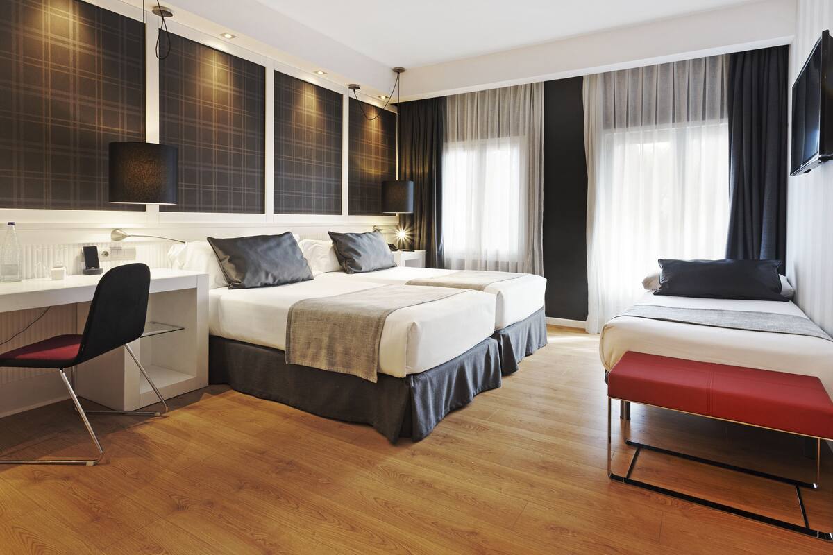 Ein modernes Hotelzimmer mit einem großen Bett, einem Schreibtisch und einem Stuhl.