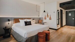 Une chambre d’hôtel moderne avec un grand lit, une petite table et une armoire.