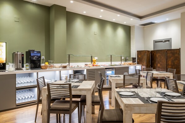Un restaurante moderno con una barra larga, varias zonas de estar y diversas opciones gastronómicas.