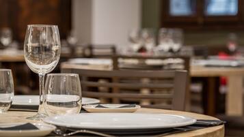 Una mesa de comedor dispuesta con platos, vasos y cubiertos.