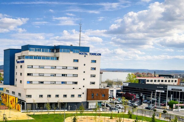 Un edificio de varios pisos con el letrero "HOSTAL TORREJON", que indica que es un hotel.