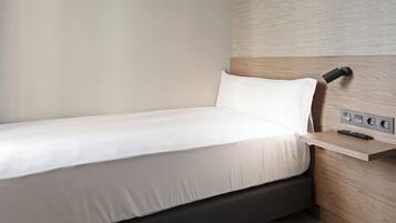 A single bed with a white mattress and a headboard with a built-in control panel.
