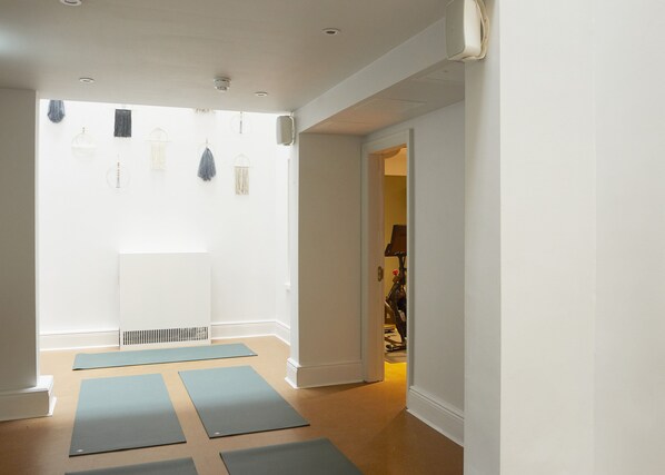A hallway with yoga mats on the floor, a radiator, and a door leading to another room. - Inhabit Southwick Street, a Member of Design Hotels (London)