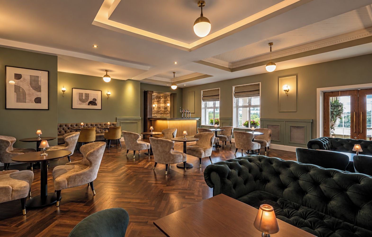 A hotel lobby with a bar area, seating arrangements, and artwork on the walls.