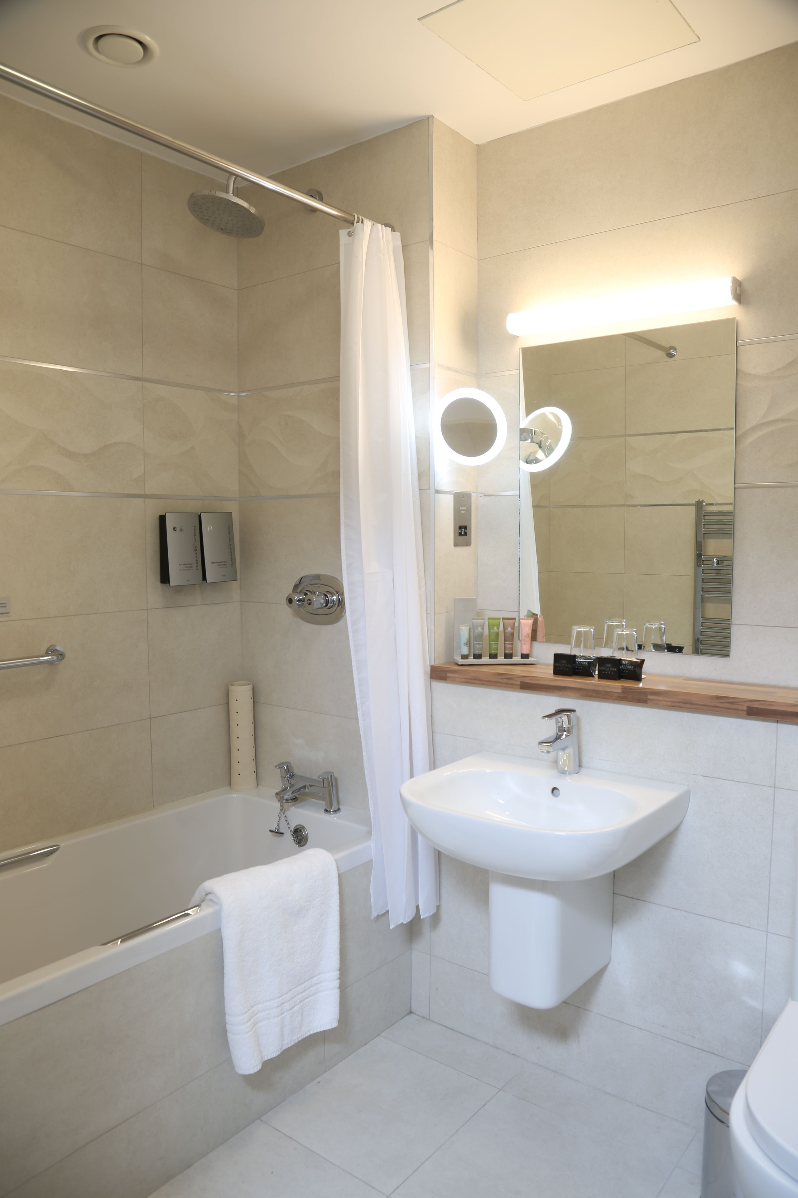 Un baño moderno con bañera, lavamanos y zona de ducha.