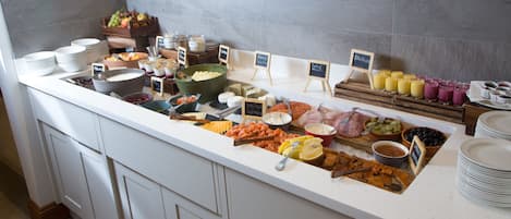 A buffet with various food items and beverages.