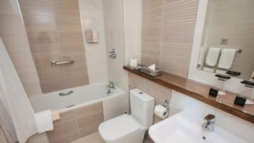 A modern bathroom with a bathtub, toilet, and sink.