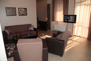 Apartamento de lujo, 1 habitación, cocina básica, vistas a la ciudad | Sala de estar | Una televisión de pantalla plana