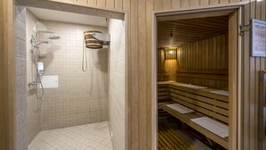 A wooden-paneled bathroom with a shower, a toilet, and a sauna area with benches. - Ratonda Centrum Hotels (Vilnius)