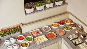 A buffet table with various food items and condiments. - Ratonda Centrum Hotels (Vilnius)