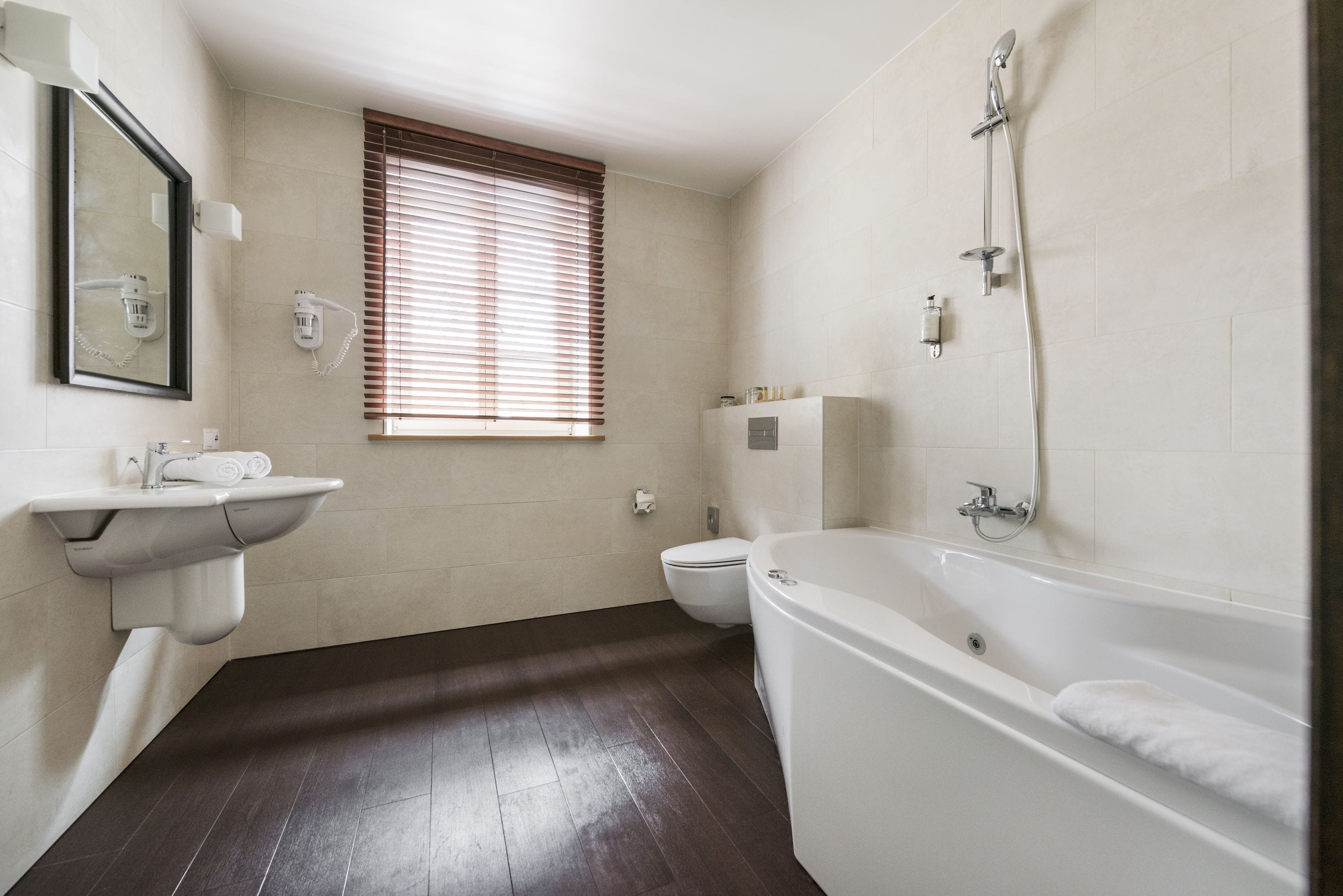A modern bathroom with a bathtub, toilet, and sink.