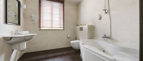 A modern bathroom with a bathtub, toilet, and sink.