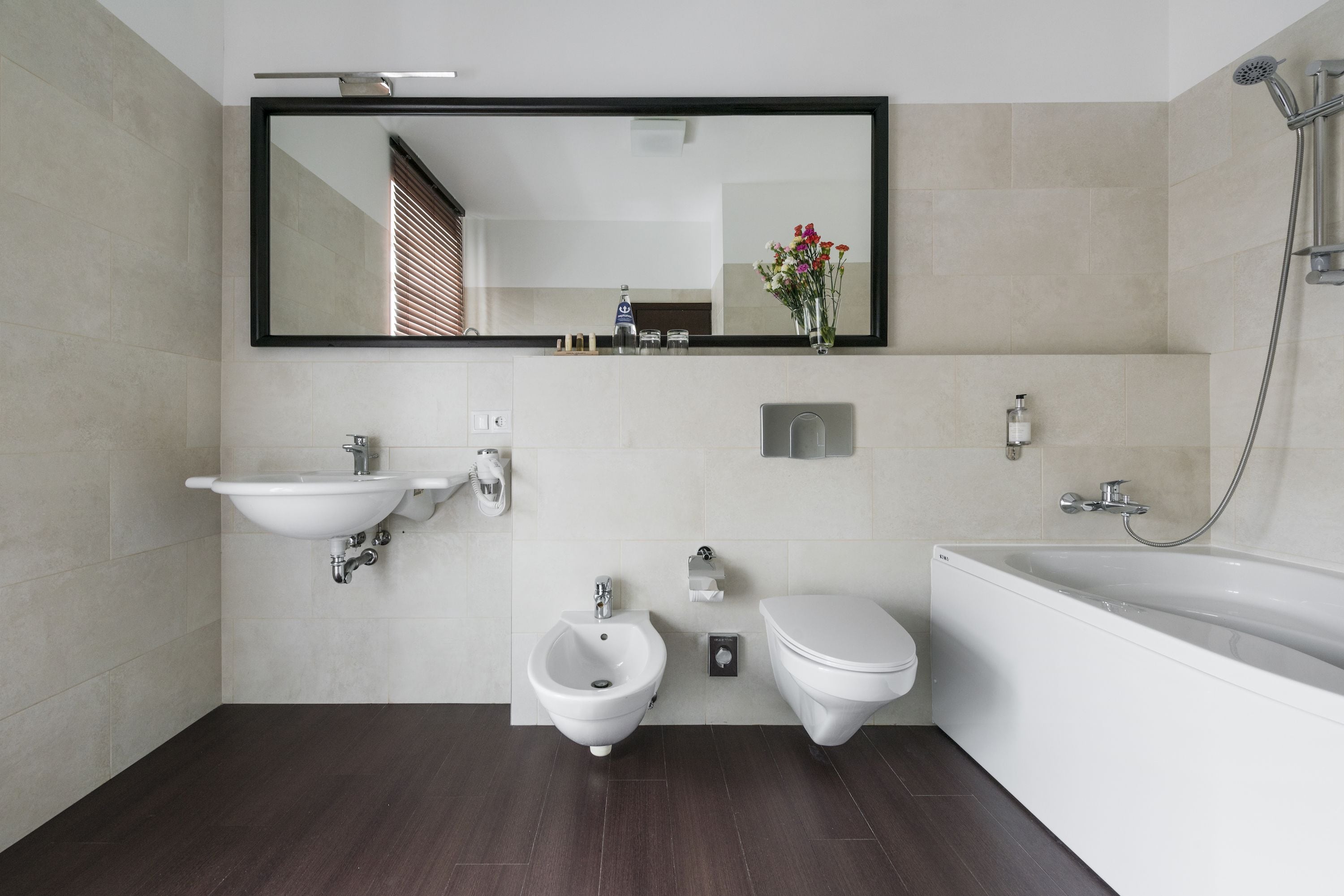 Ein modernes Badezimmer mit einer Bidet-Funktion, Toilette, Waschbecken und Badewanne.