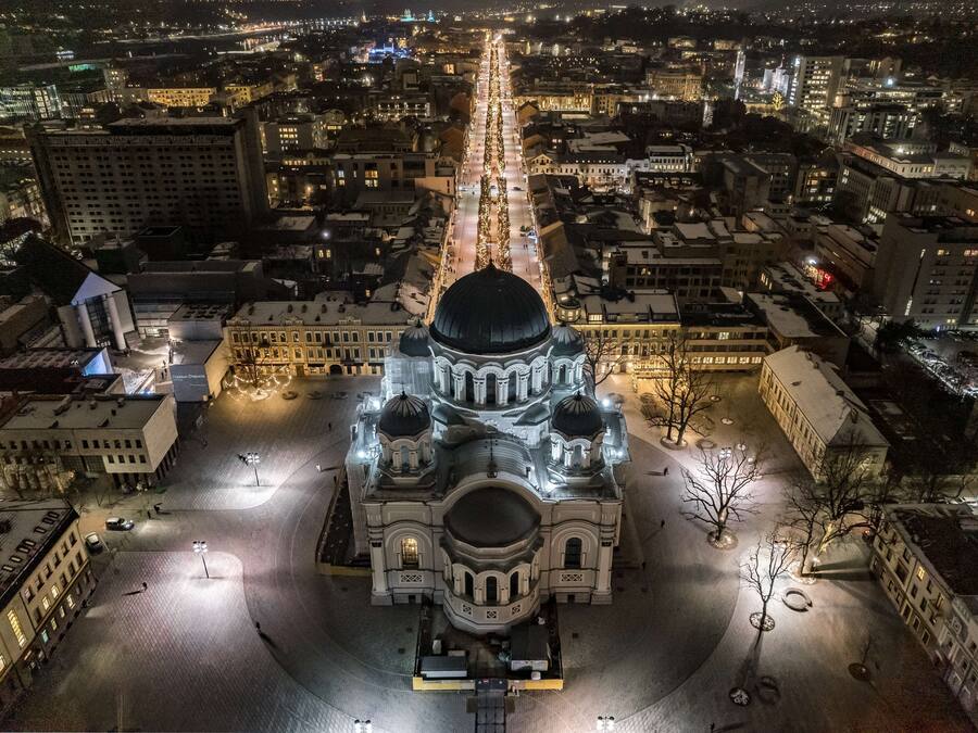 An aerial view of a historic building with a central dome and multiple smaller domes, surrounded by a cityscape at night.