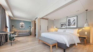 A modern hotel room with a bed, bedside tables, a desk, a chair, and a bench. - Radisson Hotel Kaunas (Kaunas)