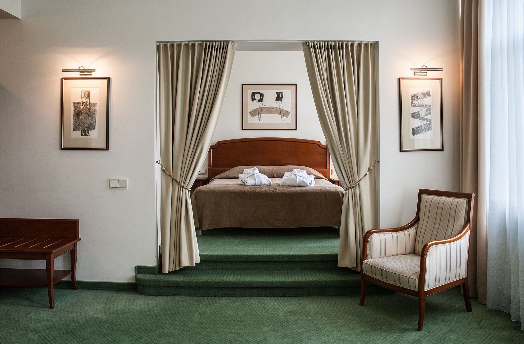 Une chambre d’hôtel avec un lit à baldaquin, une chaise et un escalier.