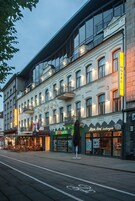 A hotel with a modern facade, large windows, and a balcony.
