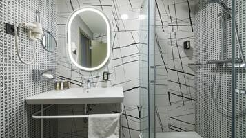 A modern bathroom with a white sink, mirror, and shower.