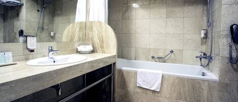 Un baño moderno con dos lavamanos, una bañera y una ducha.