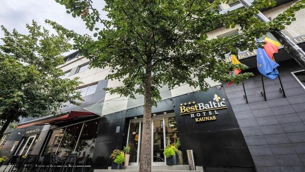 Exterior del hotel BestBaltic Kaunas, con fachada moderna, ventanas amplias y zona de estar al aire libre.