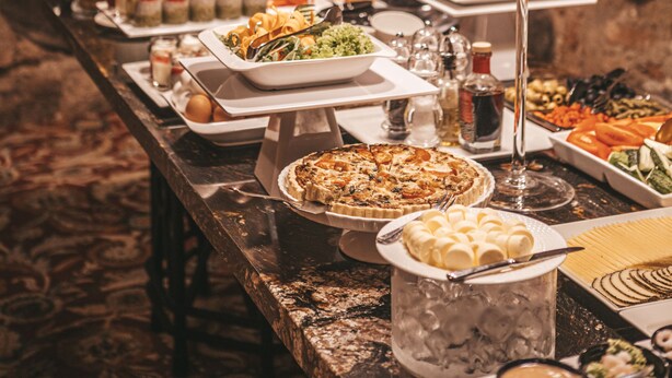 Une table de buffet garnie de divers plats et un verre à martini.