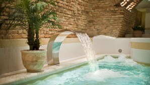 Un espace de détente avec un mur en briques, une plante en pot et un élément décoratif aquatique.