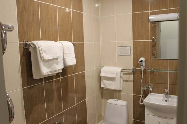A bathroom with a toilet, sink, and towel rack.