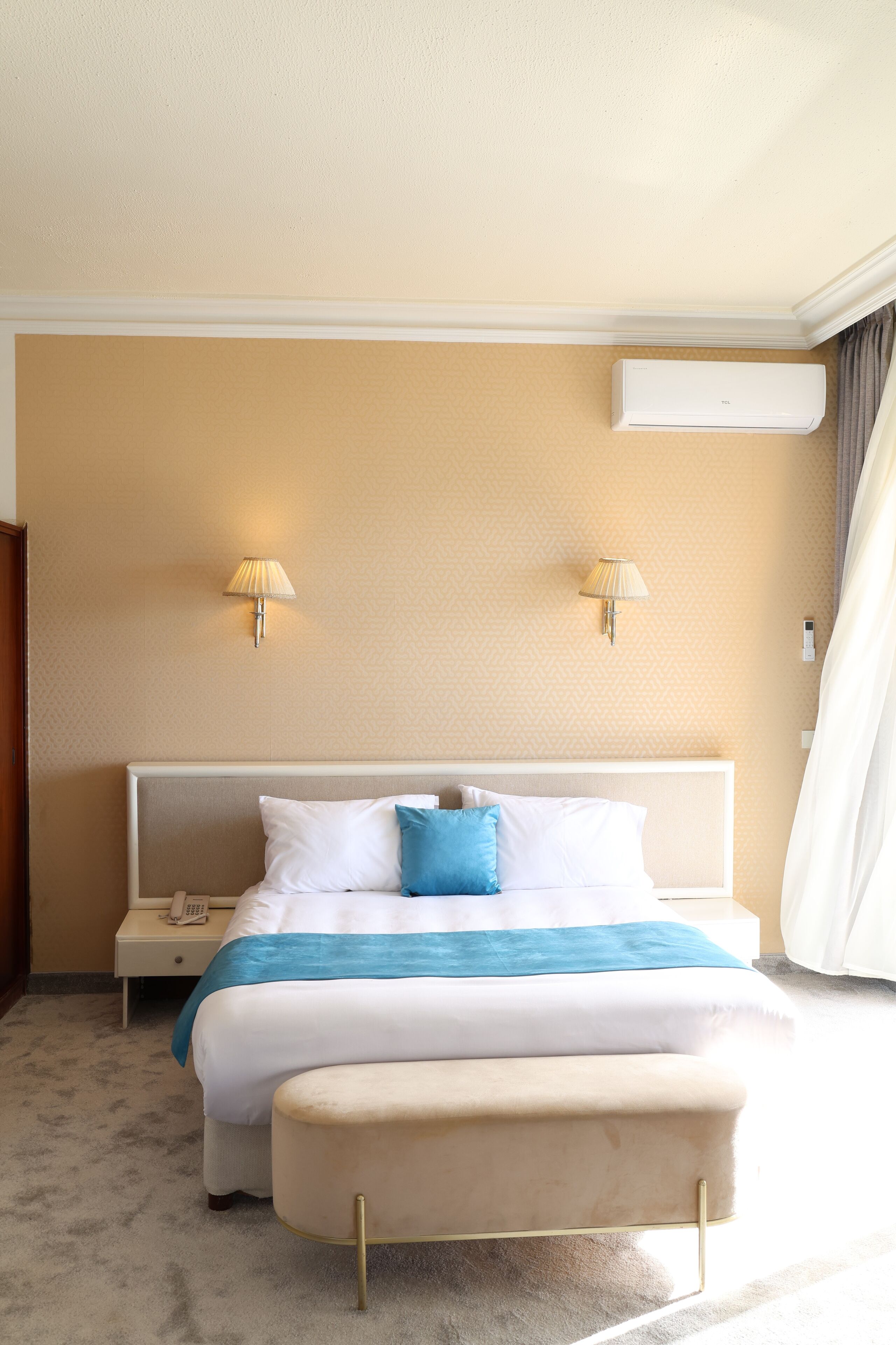 Une chambre d’hôtel équipée d’un lit, de tables de chevet, d’un appareil de climatisation et d’une lampe.