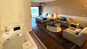 A hotel room with a large bed, a sitting area with a coffee table, a sofa, and a separate bathroom with a bathtub. - Hotel Méditerranée Beyrouth  (Beirut)