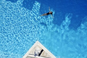 Una piscina al aire libre de temporada, sombrillas