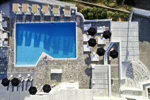 Una piscina al aire libre de temporada, sombrillas