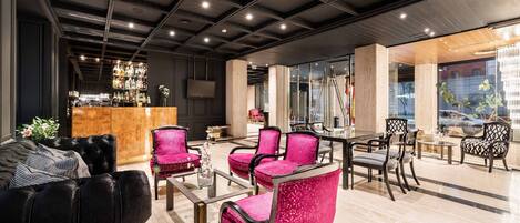 A modern lounge area with a bar, seating arrangements, and a view of the city.