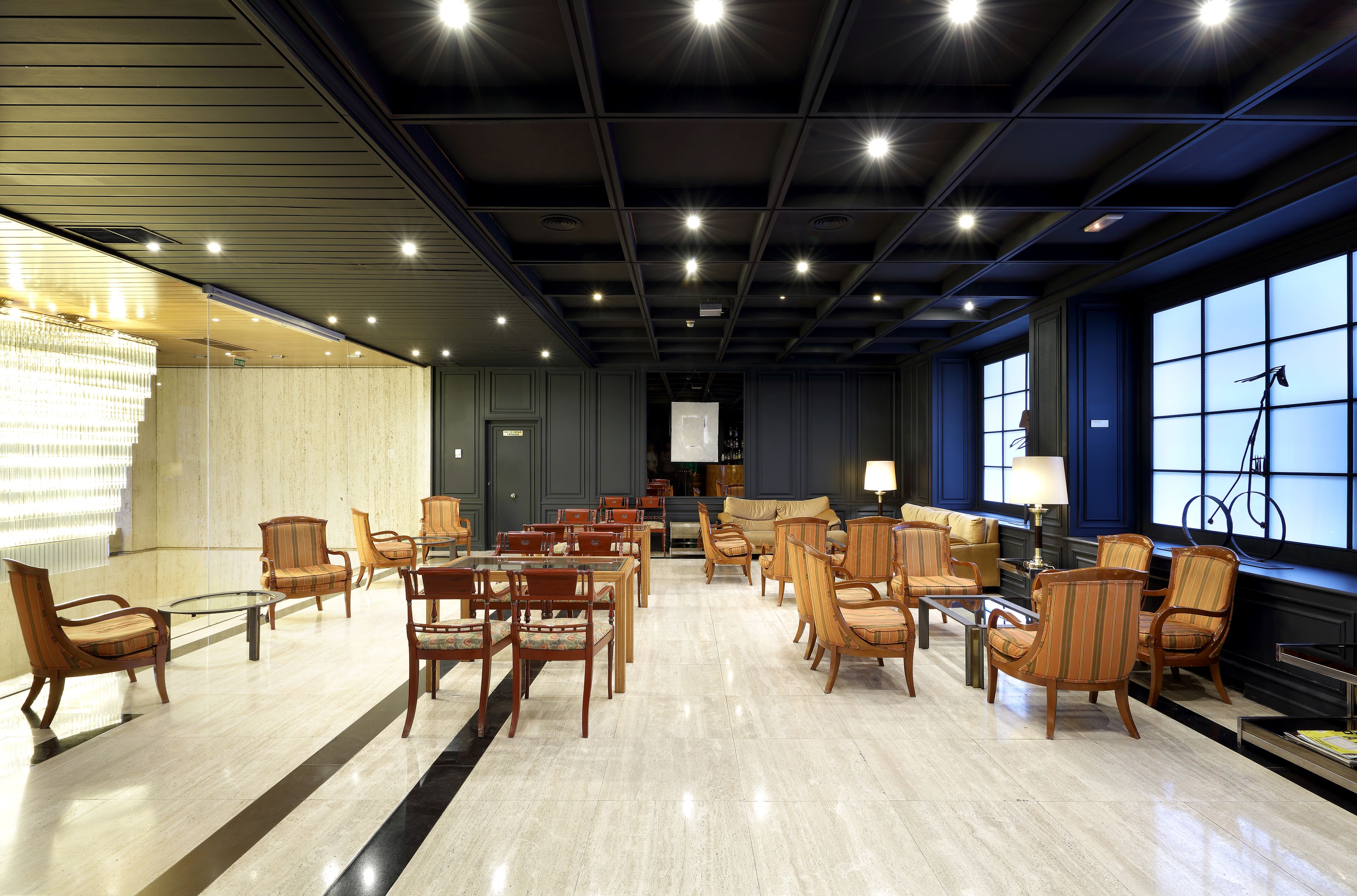 Un vestíbulo amplio con diversas zonas de estar, incluyendo sofás y sillones, dispuestas alrededor de una mesa de centro.