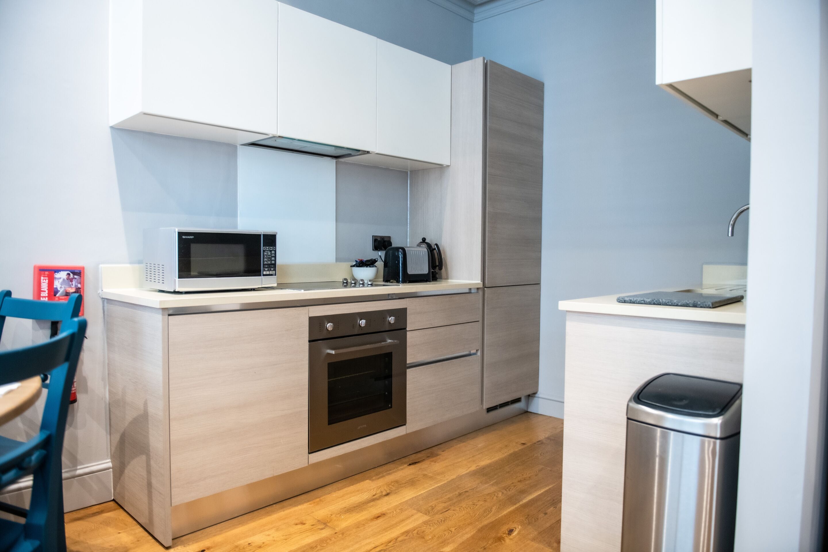 Una cocina compacta con microondas, estufa y lavamanos.