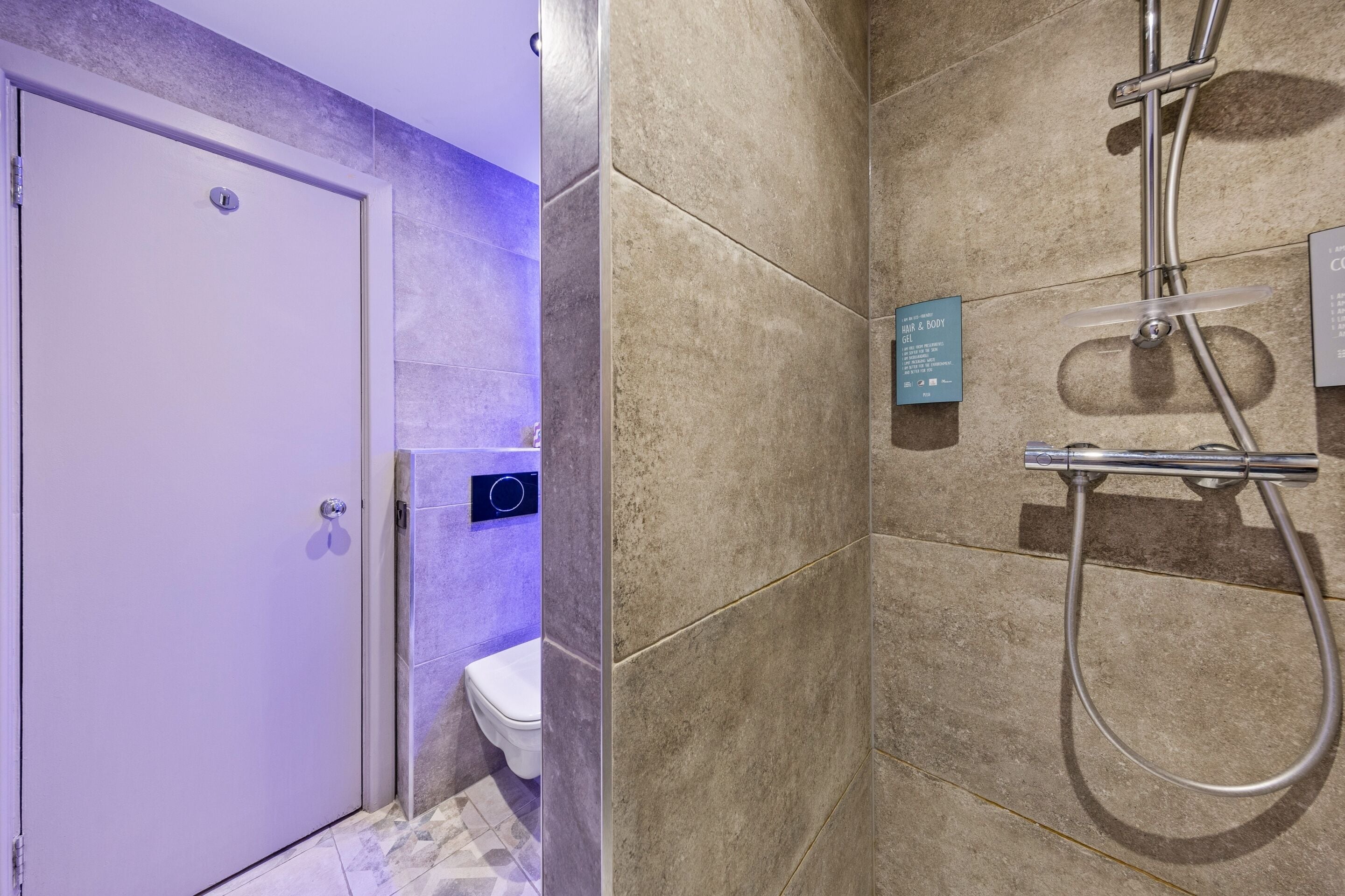 A bathroom with a shower, a toilet, and a door.