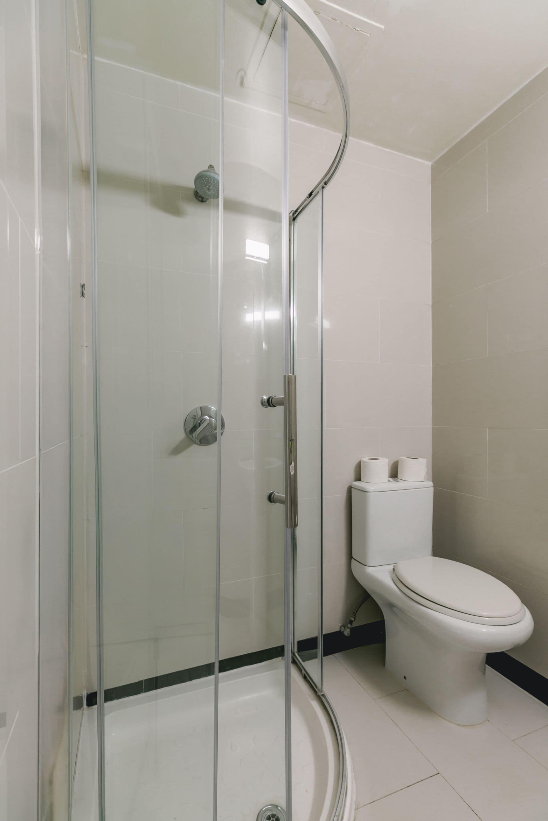 Un baño con ducha acristalada, inodoro y bidé.