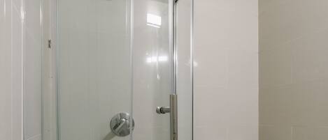 Un baño con ducha acristalada, inodoro y bidé.