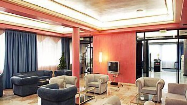 A spacious lobby with a marble floor, multiple seating areas, and a television. - Hotel Faranda Express Las Lomas (Oviedo)