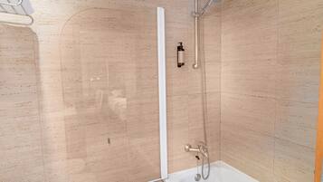 Un baño moderno con ducha de vidrio, bañera blanca y un inodoro.