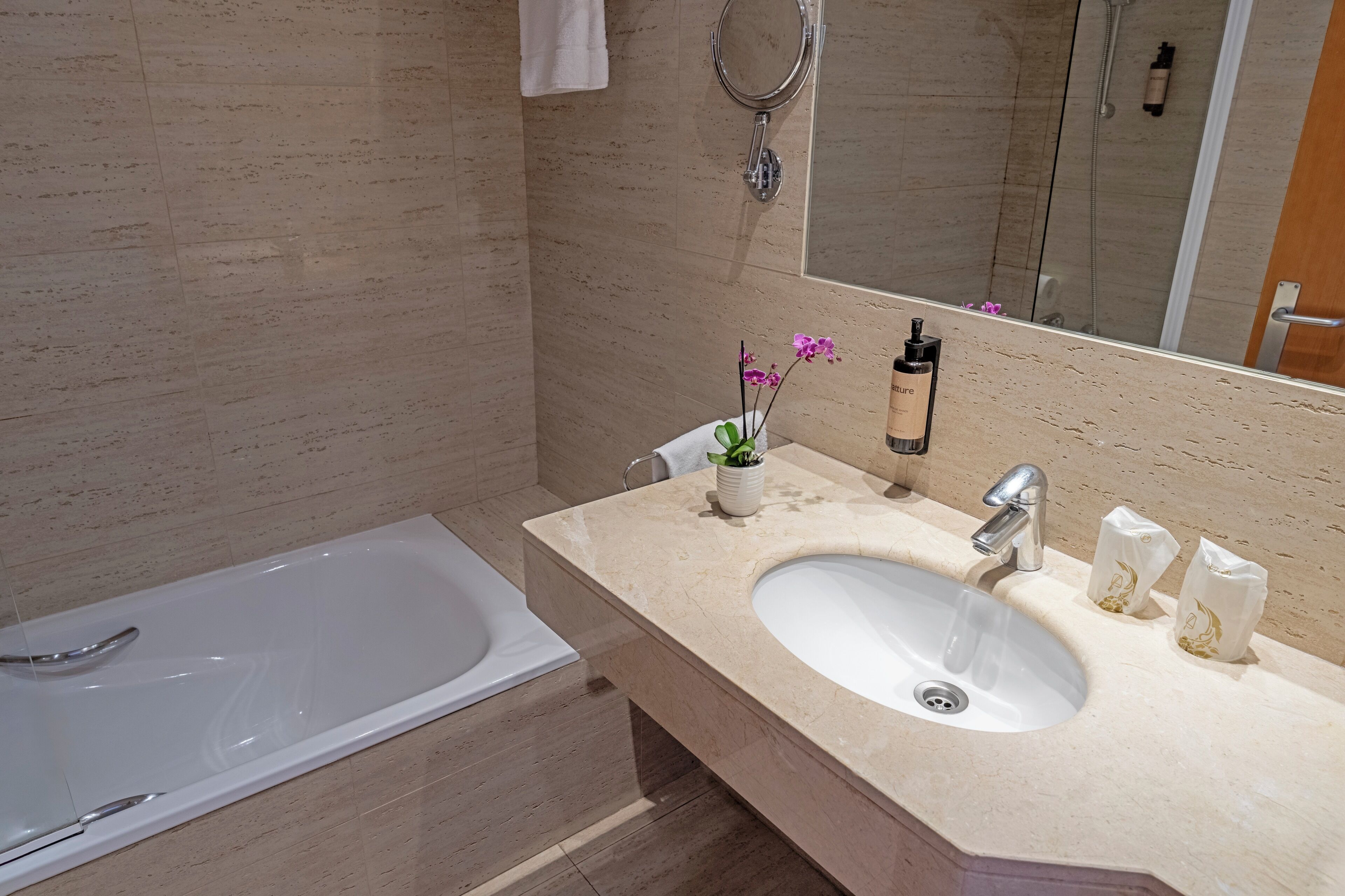 A modern bathroom with a bathtub, a sink, and a mirror.