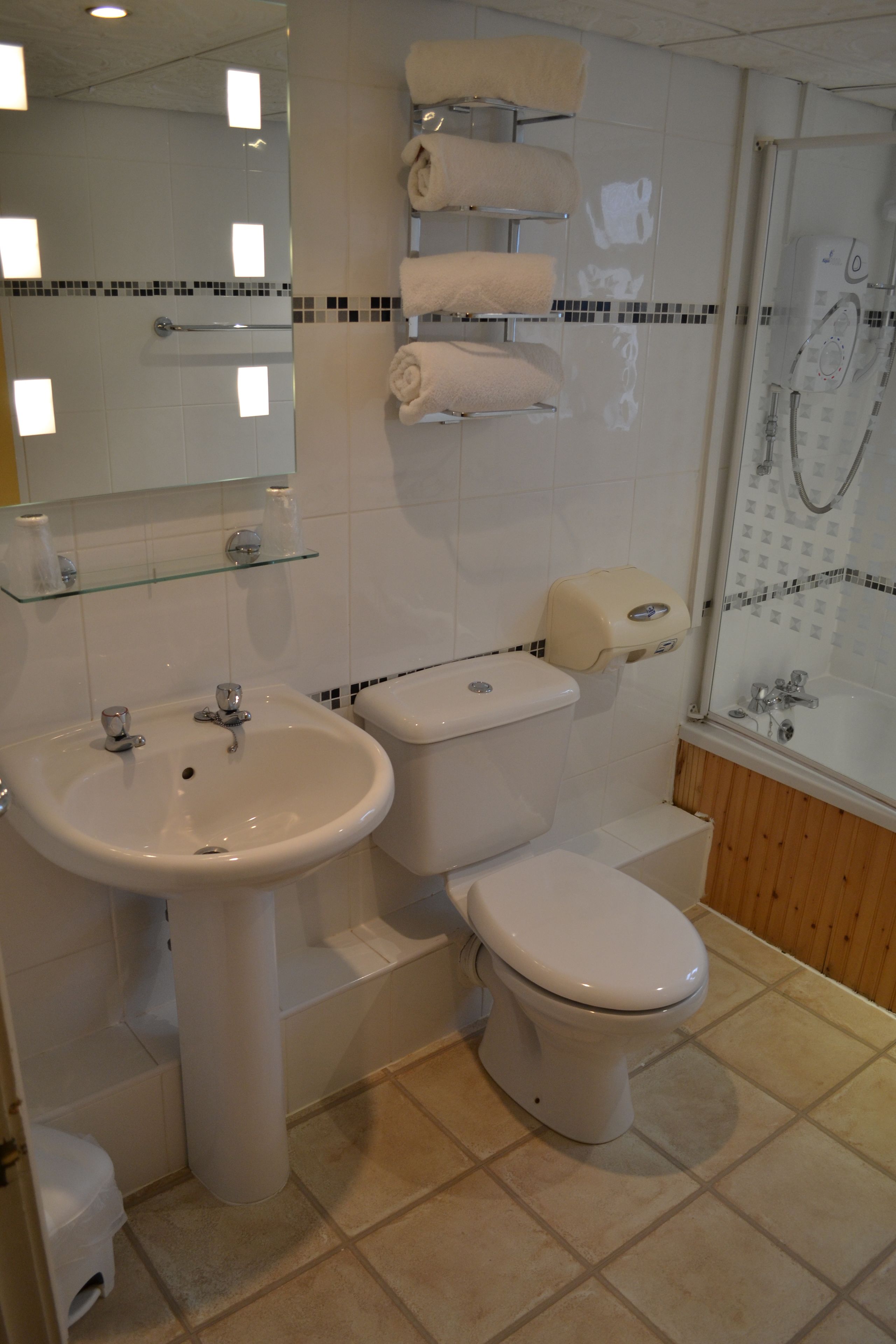 A bathroom with a sink, toilet, and glass shower enclosure.