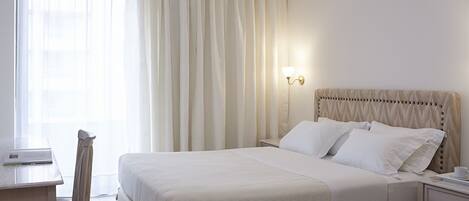 Una habitación de hotel con cama, escritorio y silla.
